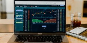 "Laptop displaying cryptocurrency trading platform with Bitcoin price chart and market data.