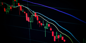 Close-up of a computer screen displaying a colorful technical analysis chart with downtrend lines and candlesticks.