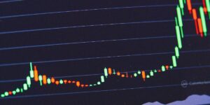  A colorful candlestick chart display on a computer monitor indicating cryptocurrency market trends over time.