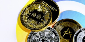 Stacked cryptocurrency coins including Bitcoin against a colorful circular background.