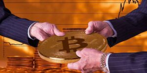 Businessmen exchanging a large Bitcoin coin with financial chart background