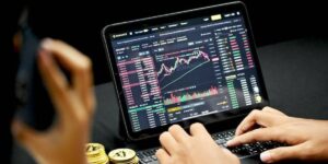 Person trading cryptocurrencies using a tablet showing market charts and data