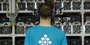 Technician monitoring ASIC miners in a cryptocurrency mining facility.