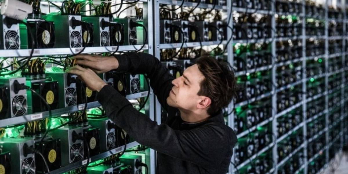 Technician working on ASIC machines in a large Bitcoin mining pools
