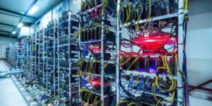 Rows of cryptocurrency mining rigs with connected cables and mining software running to optimize the mining process.