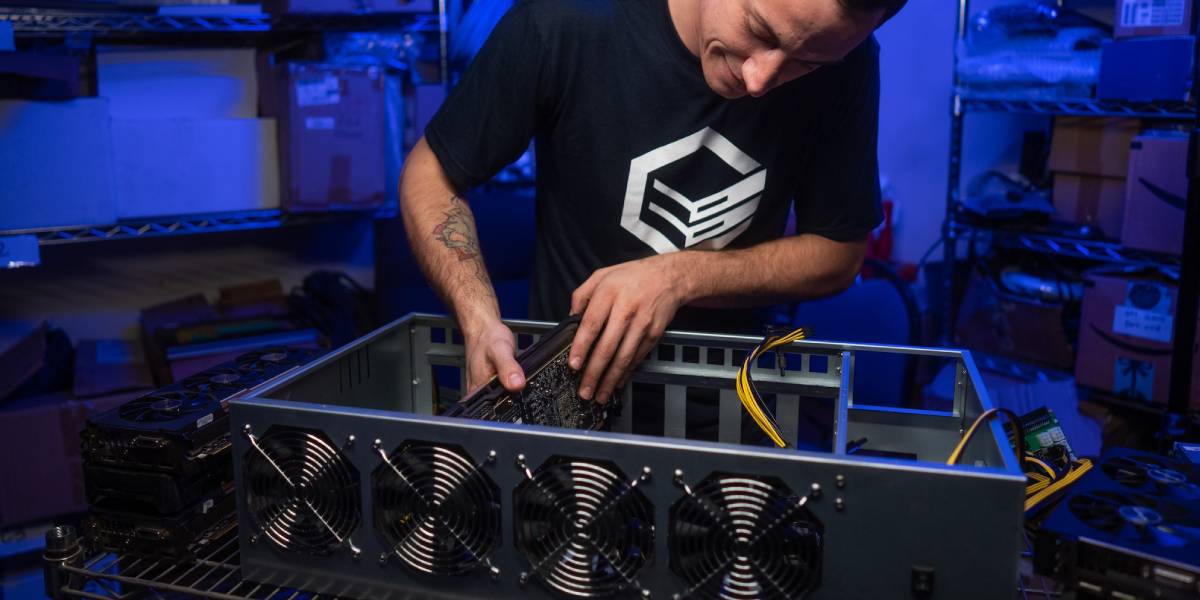 A crypto miner assembling a GPU mining rig, carefully installing graphics cards in a high-performance mining setup.