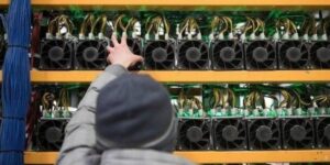 Person adjusting ASIC miners on a server rack in a bitcoin mining facility 