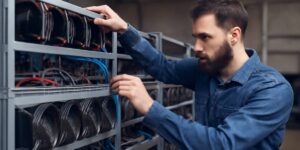 Technician inspecting crypto mining hardware on a rack