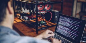 Solo miner running benchmarking and performance tuning scripts on a laptop connected to a GPU mining rig.