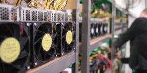 Close-up of cryptocurrency mining rigs with cooling fans inside a mining facility