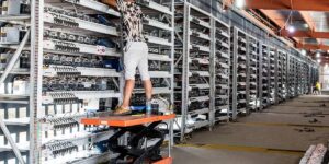 Technician maintaining Asic miners inside a large-scale Bitcoin mining facility with rows of ASIC mining machines