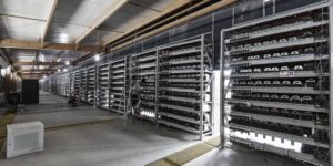 Large cryptocurrency mining farm operating Bitcoin miners in industrial racks for Bitcoin mining