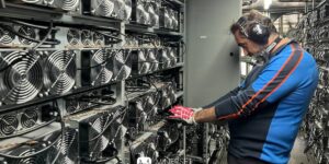 Bitmain miners operating in a large cryptocurrency mining facility with technician maintaining ASIC mining rigs