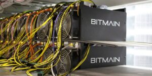 Bitmain ASIC miners connected with network cables inside a cryptocurrency mining facility.