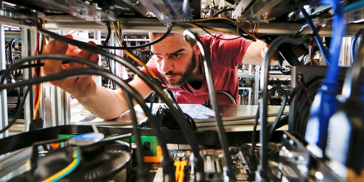 Bitcoin mining pool technician inspecting ASIC mining rigs and network cables inside a crypto mining facility.