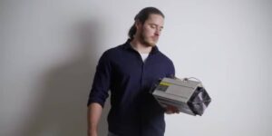 Man holding a specialised cryptocurrency mining machine